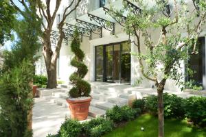 a garden in front of a building with trees at HUMA Kotor Bay Hotel and Villas in Kotor