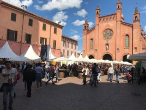 a group of people walking around a market in front of a building at Casa Bona in Alba