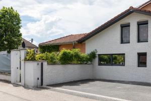 a white house with a fence and a driveway at Trendy studios Tassin in Tassin-la-Demi-Lune