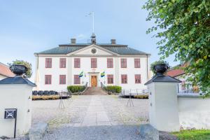 un gran edificio blanco con una puerta. en Mauritzbergs Slott & Golf, en Mauritsberg