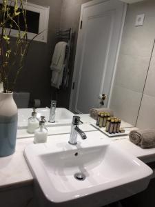 La salle de bains est pourvue d'un lavabo blanc et d'un miroir. dans l'établissement Casa da Galega, à Golegã