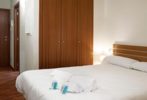 索爾德烏的住宿－Andorra4days Soldeu - El Tarter，卧室配有白色床和毛巾