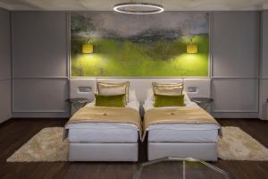 2 Betten in einem Zimmer mit Wandgemälde in der Unterkunft Boutique Hotel Center in Kecskemét