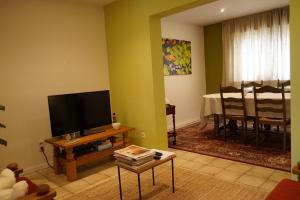 a living room with a flat screen tv and a table at RectoVersoVV in Sint-Pieters-Leeuw