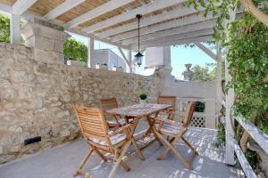 einen Tisch und Stühle auf einer Terrasse mit einer Steinmauer in der Unterkunft Villa Marchi in Hvar