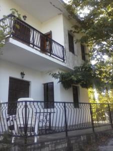 a white building with a balcony and a fence at Holiday Home Neochori in Neochori