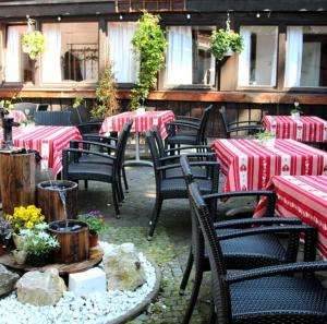 un grupo de mesas y sillas con manteles rojos y blancos en König Ludwig Stub´n en Prien am Chiemsee
