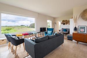 康卡勒的住宿－Le Sémaphore - Maison avec vue face à la mer，带沙发和椅子的客厅以及大窗户。