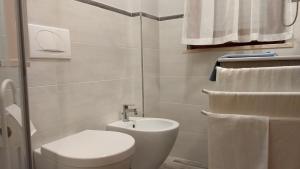een witte badkamer met een toilet en een wastafel bij IL QUADRIFOGLIO Mare e Relax in Tortoreto Lido