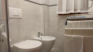 a white bathroom with a toilet and a sink at IL QUADRIFOGLIO Mare e Relax in Tortoreto Lido