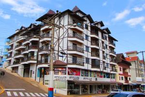 Un gran edificio blanco con balcones en una calle. en Apartamentos Morada do Sol, en Piratuba