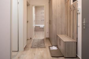 a bathroom with a wooden floor and a hallway at Brasov Holiday Apartments in Braşov +191 photos