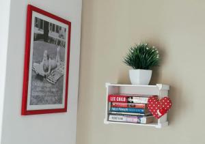 a book shelf with books and a potted plant at B&B Sweet Home Two Steps From The Ruins... in Pompei