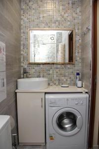 a bathroom with a washing machine and a sink at Pearl apartment in Kutaisi in Kutaisi