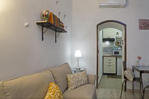 a living room with a couch and a kitchen at Casa Rosa al Molo by Wonderful Italy in Genoa