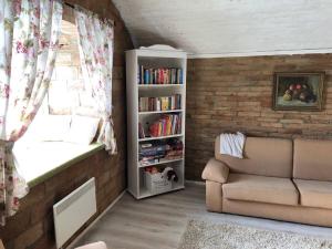 ein Wohnzimmer mit Sofa und Bücherregal in der Unterkunft Kakukkfu Barlang-Vendeghaz in Noszvaj