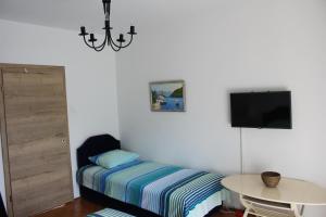 a bedroom with a bed and a table and a tv at Casa Agava Becici in Bečići