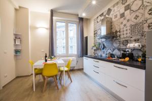 a kitchen with a table and yellow chairs at La Dotta Apartments in Bologna