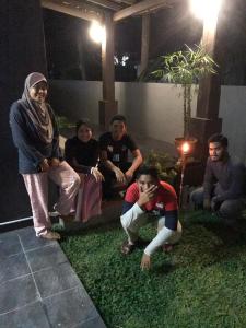 grupa ludzi siedzących na trawie w nocy w obiekcie Rose Guest House w mieście Kota Bharu