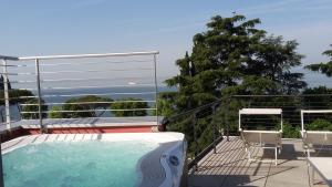 a swimming pool on a balcony with chairs and a tree at Hotel Europa in Garda
