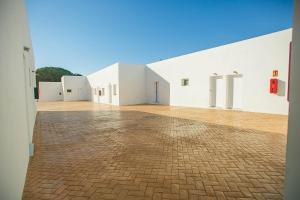 a large white building with a brick floor at Hostal el Pinar Cadiz in Puerto Real