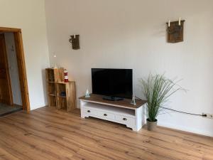 a living room with a television on a white cabinet at Lubblerhof in Fehmarn
