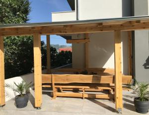 un banc en bois sur une terrasse ornée de plantes dans l'établissement Apartments Villa Stivan, à Solin