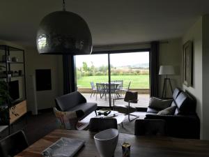 a living room with a couch and a table with chairs at Coolcottage des 2 Caps in Leulinghen-Bernes