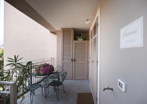 d'un balcon avec une table, des chaises et une porte. dans l'établissement Residenza Belmare, à Marina di Carrara