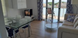 sala de estar con mesa de cristal y sofá en Apartament La Fosca Palamós, en Palamós