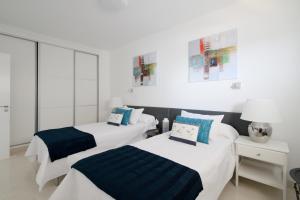 two beds in a room with white and blue at Tropical Treat in Playa del Ingles