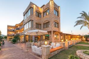 a building with tables and chairs in front of it at Danelis Studios & Apartments in Malia