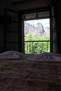 Schlafzimmer mit einem Fenster mit Blick auf den Canyon in der Unterkunft Guesthouse Vavitsas in Kalambaka