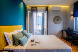 1 dormitorio con 1 cama con pared verde en Aethra Boutique Rooms, en Nauplia