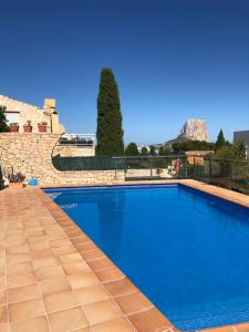 einen großen blauen Pool mit einer Steinmauer in der Unterkunft Villa Manzanera in Calpe