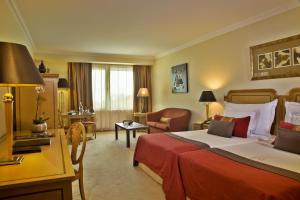 a hotel room with a bed and a chair and a desk at Hotel Cascais Miragem Health & Spa in Cascais