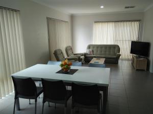 a living room with a table with chairs and a couch at Near Train Station in Perth