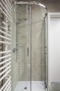 um chuveiro com uma porta de vidro na casa de banho em Apartamenty Natalia - bezpłatny parking em Krynica-Zdrój