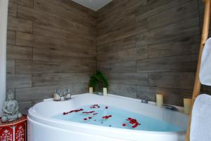 a bathroom with a tub with red flowers in it at B&B Amor in Rome