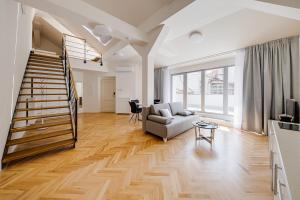 a living room with a staircase and a couch at Gold Art Apartments in Prague