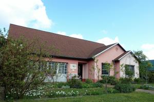 a pink house with a brown roof at Ferienhaus Friedrichswalde in Friedrichswalde
