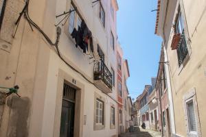 Une ruelle dans une vieille ville avec des bâtiments dans l'établissement MyPlaceLisbon - Mouraria Duplex, à Lisbonne