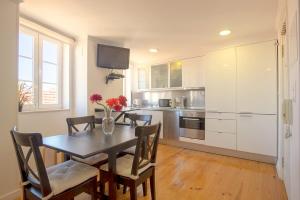 a kitchen with a table and chairs and a kitchen with white cabinets at MyPlaceLisbon - Mouraria Duplex in Lisbon