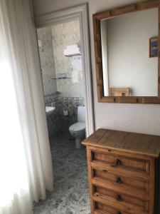 ein Badezimmer mit Waschbecken, Toilette und Spiegel in der Unterkunft Hotel Hoya in Noja + 35 Fotos