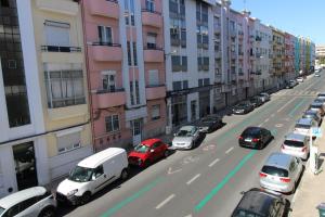 a busy city street with cars parked on the street at Sete Rios, Near Zoo Lisboa/ free Wifi in Lisbon