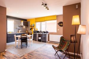 a kitchen with yellow walls and a table and chairs at VILLA ZENITH Hostel-LA SURF HOUSE in Lacanau-Océan