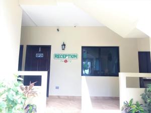 eine weiße Tür mit einem Schild, das den Empfang liest in der Unterkunft Jan's Hotel in Caye Caulker + 36 Fotos