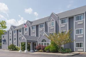 a large gray building with an american flag at Microtel Inn & Suites by Wyndham Uncasville Casino Area in Uncasville