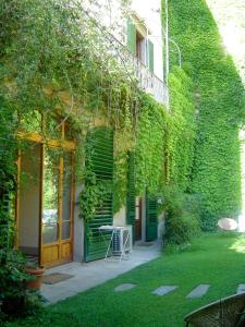 a building covered in green ivy with a table in the yard at Le Tre Stanze in Florence