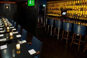 un restaurante con mesas y sillas y un bar en Fitzpatrick Manhattan, en Nueva York